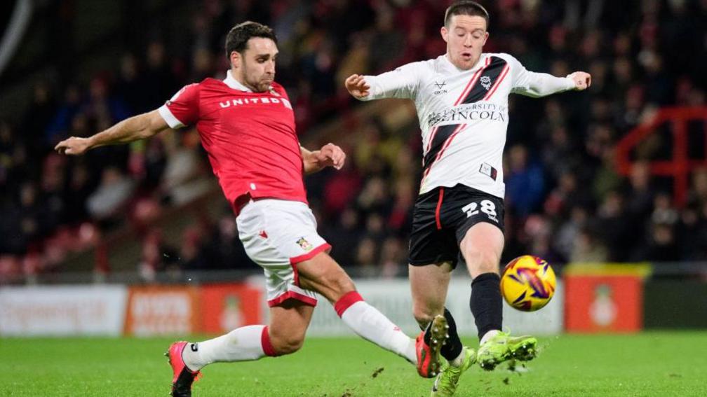 Matty James vies for possession with Lincoln City's Jack Moylan during Wrexham's 1-0 win in League One