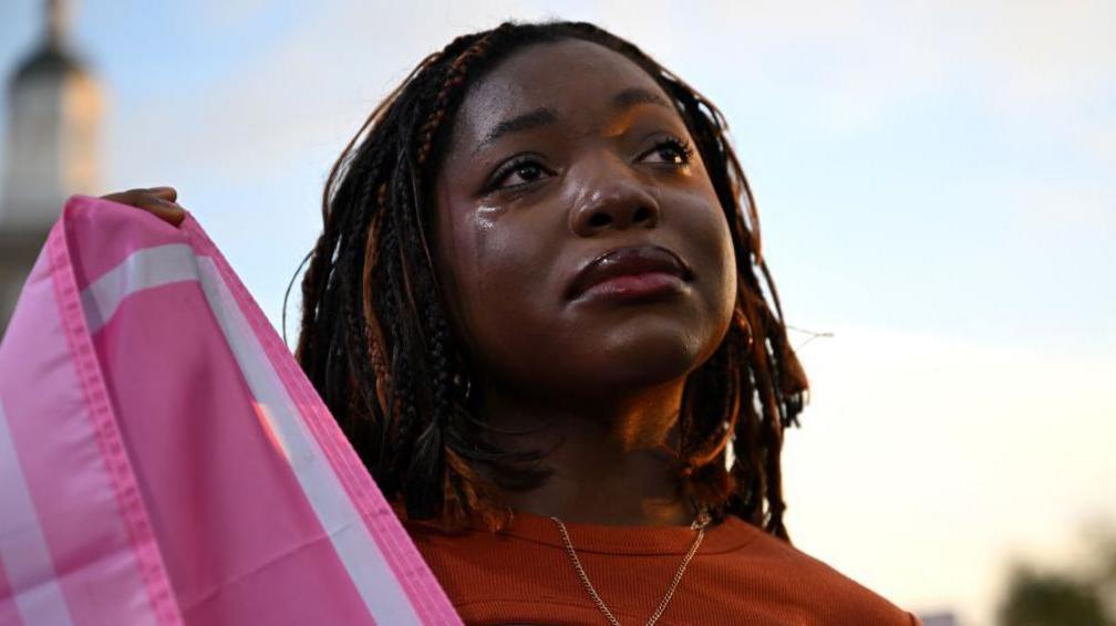 A black woman crying as she watches Harris