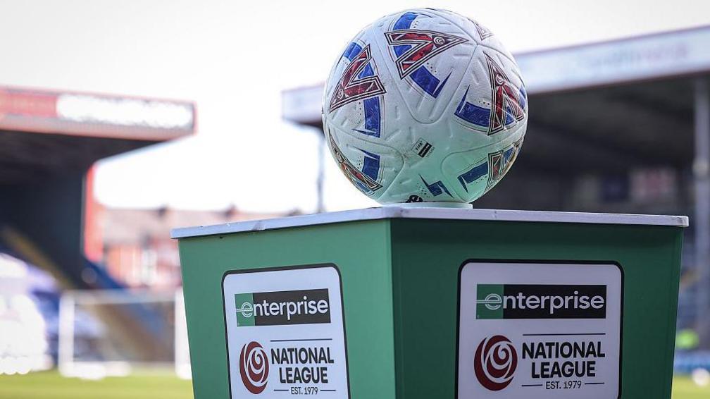 A football balanced on a green plinth bearing the name of the Enterprise National League