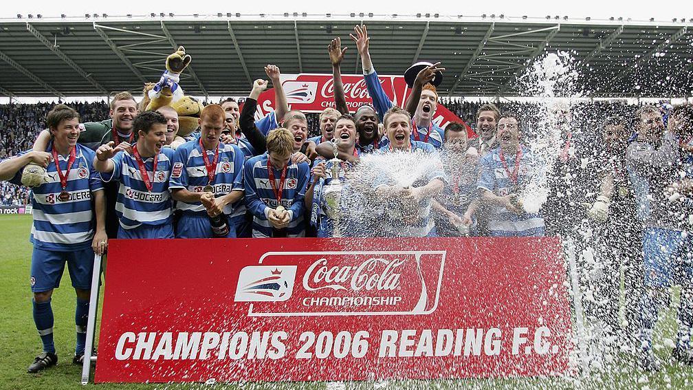 Reading players celebrating and spraying champagne after being presented with the Championship trophy at the then Madejski Stadium in Reading.