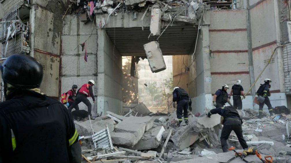 Rescue workers conduct search and rescue operation at a high-rise residential building partially destroyed by Russian shelling on September 24, 2024 in Kharkiv, Ukraine