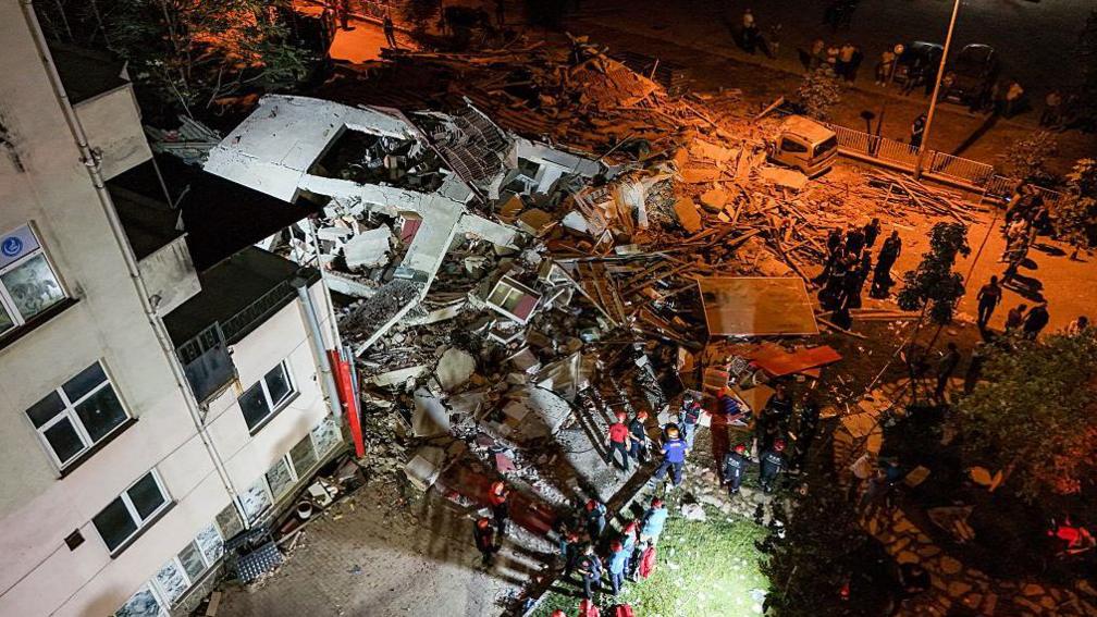 Another aerial view of a collapsed building and you can see that cars were crushed under the debris.