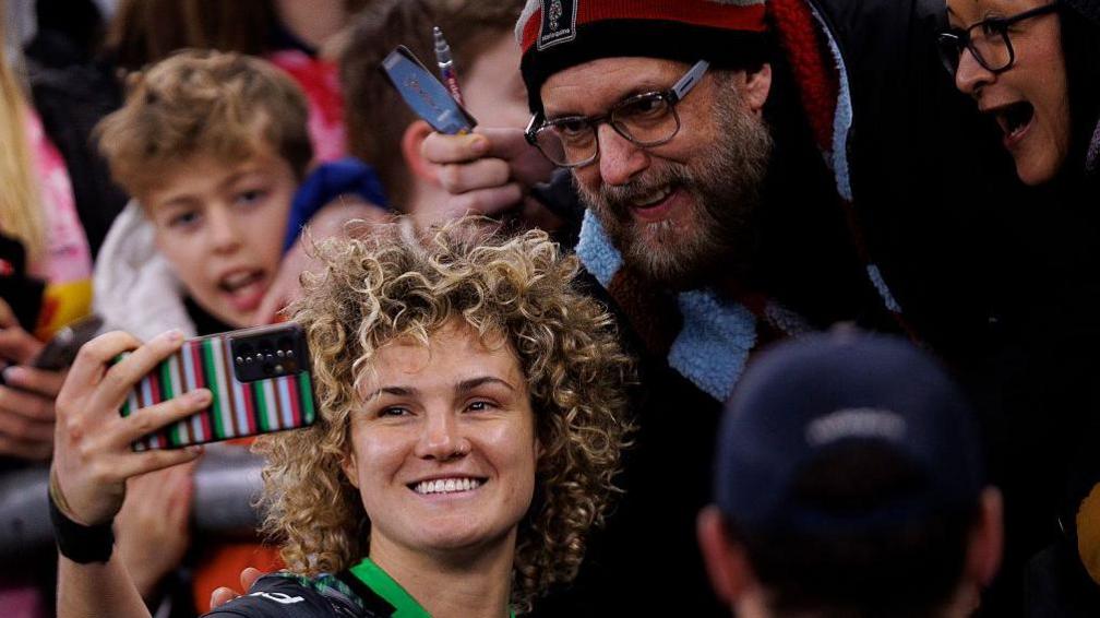 Ellie Kildunne takes a photo with fans