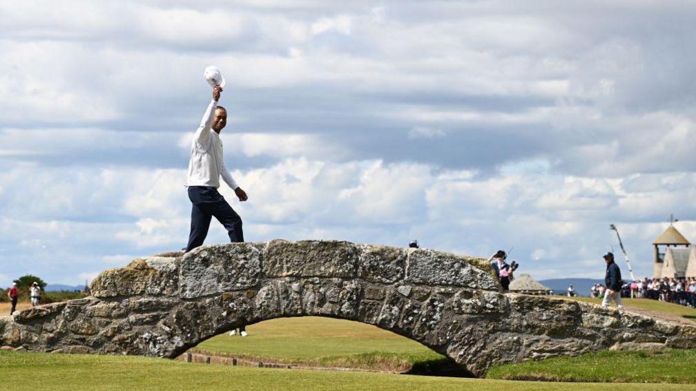 Tiger Woods of the United States acknowledges the crowd on the Swilcan Bridge on the 18th hole during Day Two of The 150th Open at St Andrews Old Course on July 15, 2022 in St Andrews, Scotland.