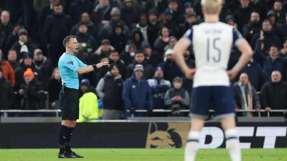 Referee Stuart Attwell is talking during Tottenham's League Cup game against Liverpool