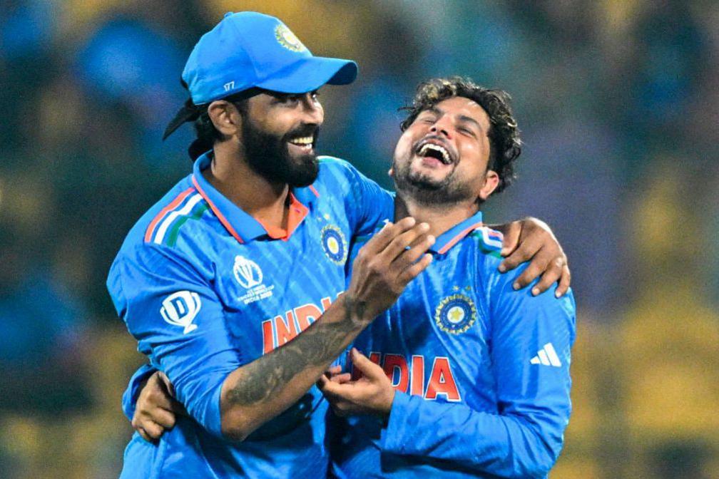 India's Kuldeep Yadav (R) celebrates with Ravindra Jadeja after taking the wicket of Netherlands' Logan van Beek during the 2023 ICC Men's Cricket World Cup one-day international (ODI) match between India and Netherlands at the M. Chinnaswamy Stadium in Bengaluru on November 12, 2023