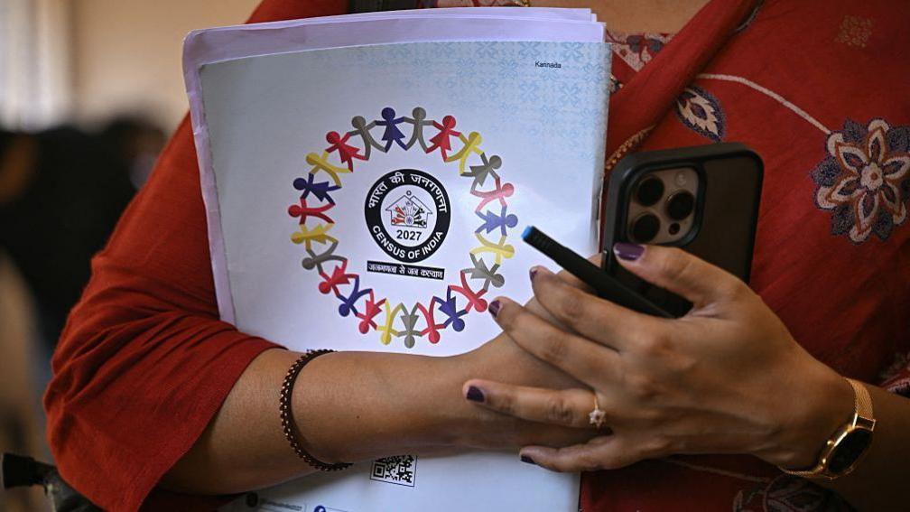 An enumerator holds India's upcoming census 2027 documents 