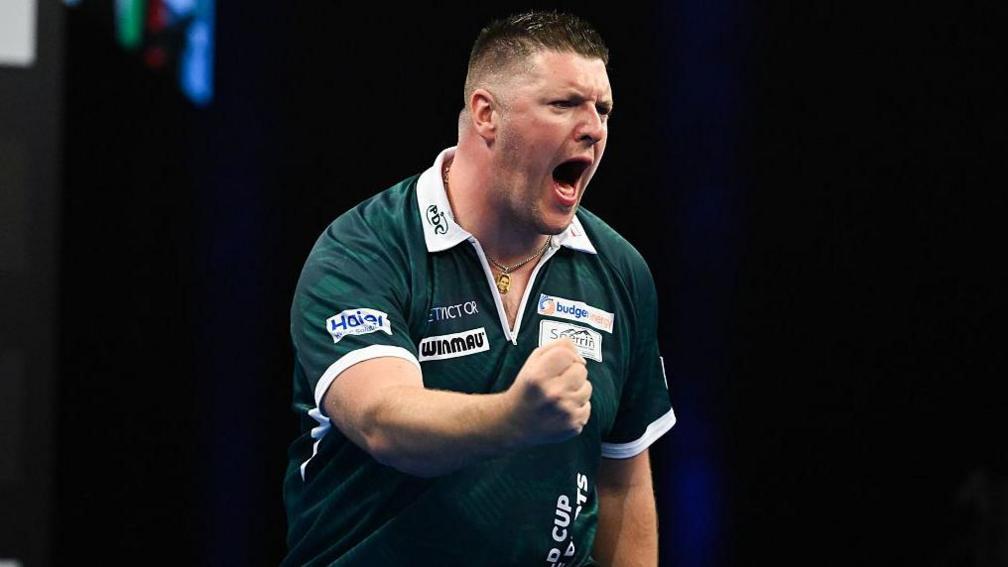 Daryl Gurney clenches his fist in delight as he wins the World Cup of Darts for Northern Ireland