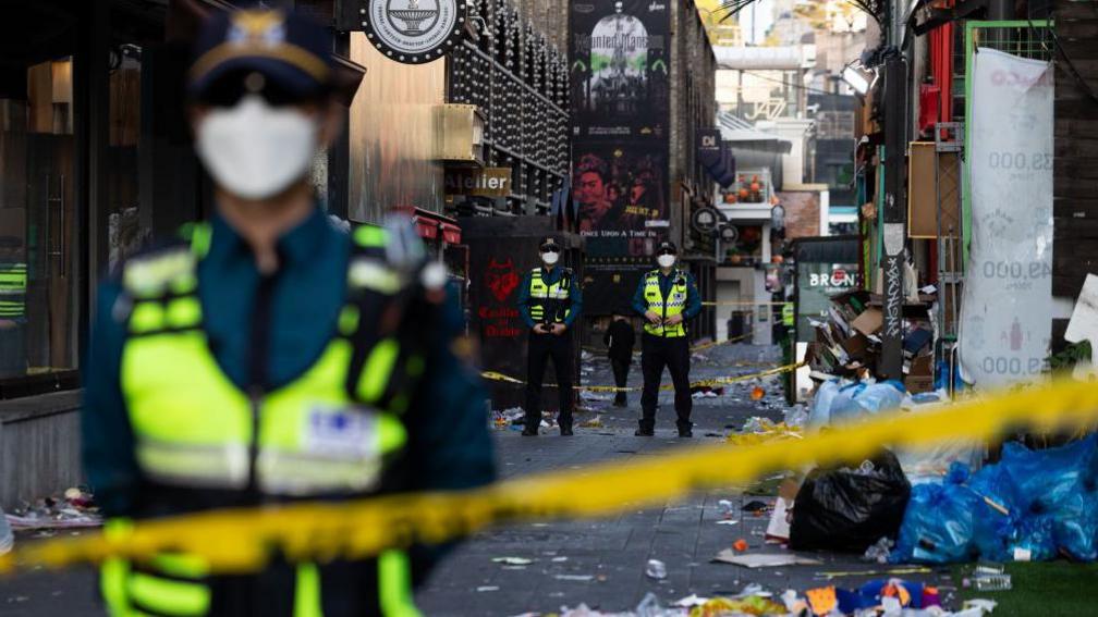 Police officers stand guard behind a cordon in the Itaewon district of Seoul, South Korea, on Sunday, Oct. 30, 2022. 