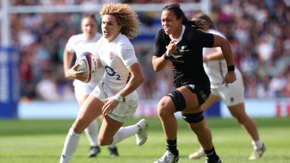 Ellie Kildunne carries the ball away from an All Blacks player