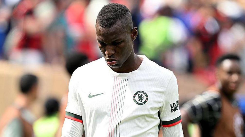 Chelsea striker Nicolas Jackson looks downward after receiving a red card