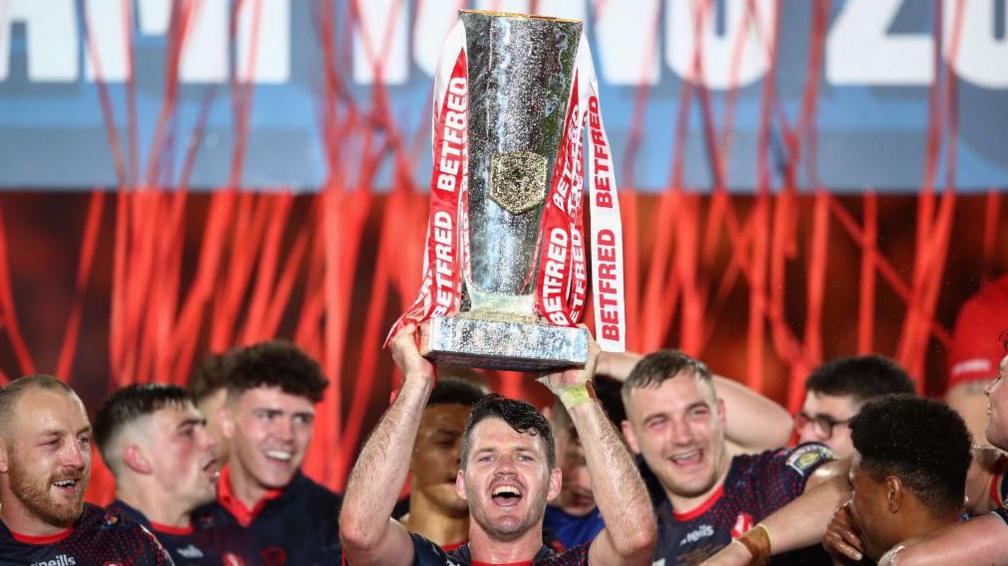 Lachlan Coote lifts the trophy following St Helens victory in the Betfred Super League Grand Final match against Catalans Dragons at Old Trafford in 2021