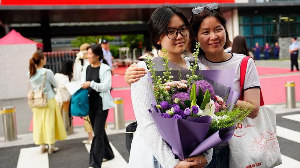 A mother hugs her daughter for a commemorative photo, wishing her good grades on June 9, 2026 in Beijing, China. 