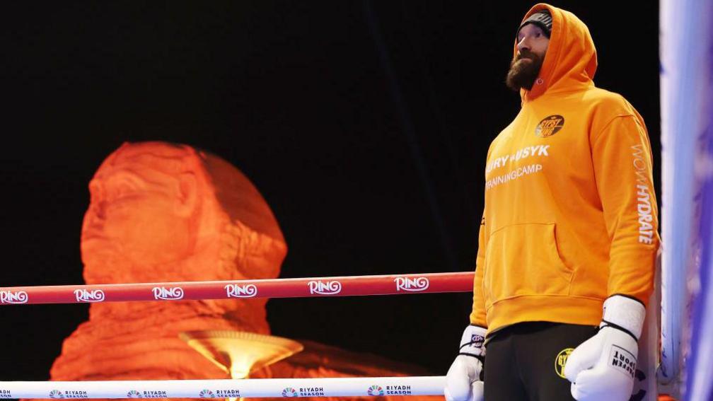 Tyson Fury in an orange hoodie in the ring