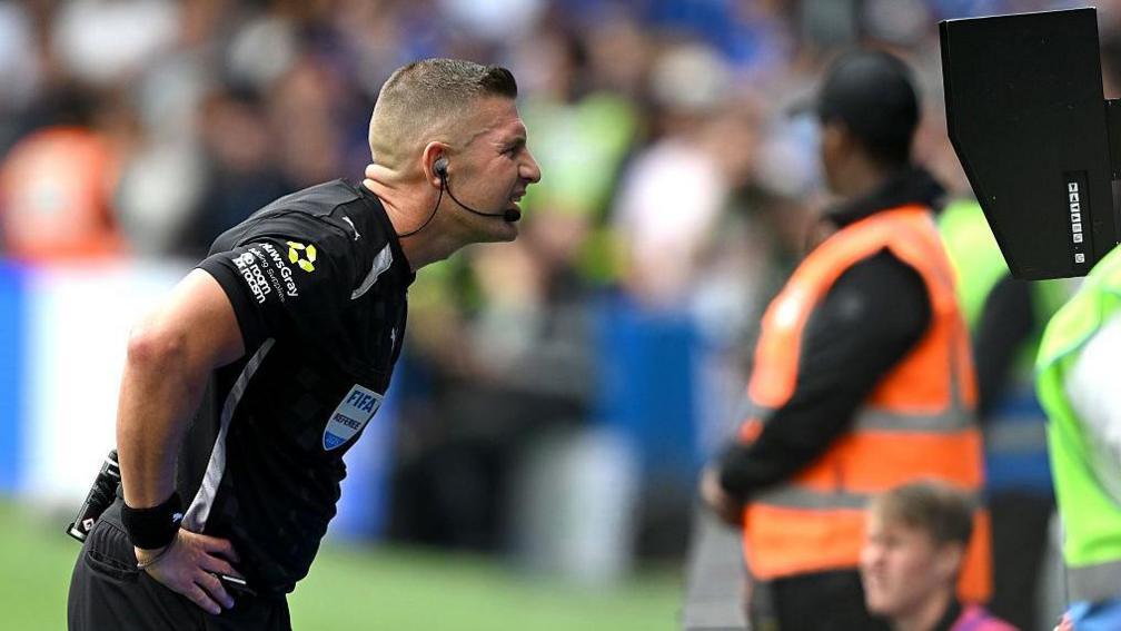 Feferee Robert Jones checks the VAR screen during a match between Fulham and Chelsea