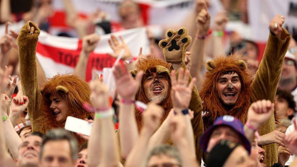England fans wearing lion fancy dress costumes show their support during their opening match against Croatia.