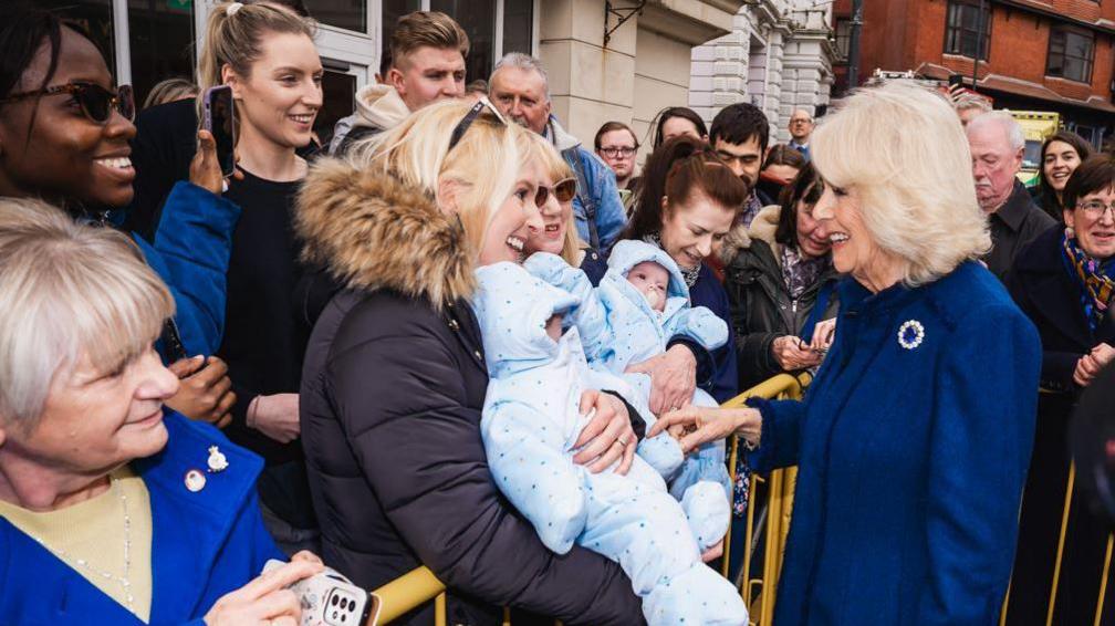 Mother with twins speaking to Queen Camilla