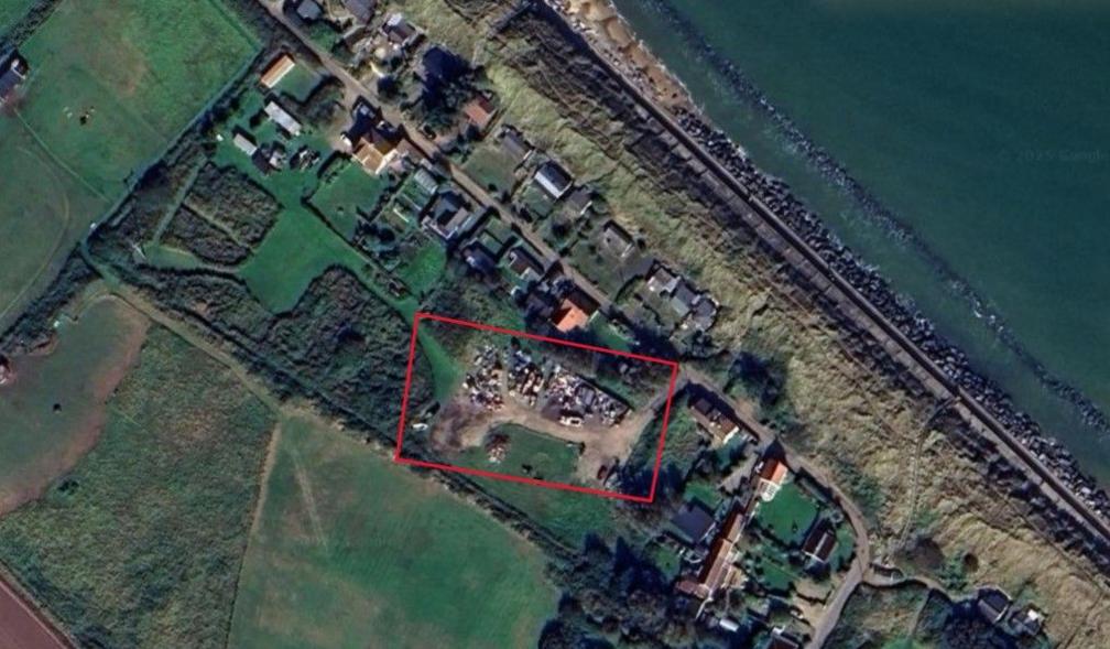 A satellite image taken from above shows the location of a fishing yard near the coast and more than a dozen or so other properties. A red rectangle has been drawn around the yard to show its exact location.