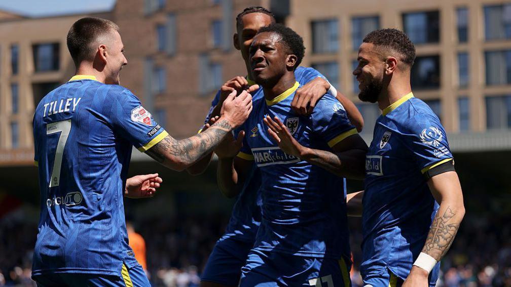 AFC Wimbledon players celebrate after Josh Neufville's opening goal