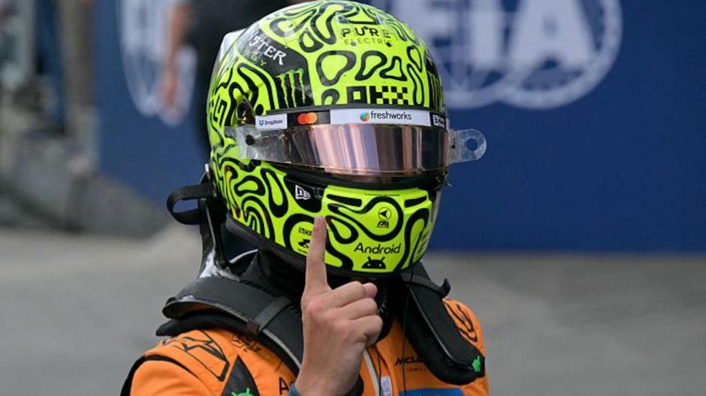 McLaren's Lando Norris holds his right index finger up in celebration after taking pole position for the Sao Paulo Grand Prix