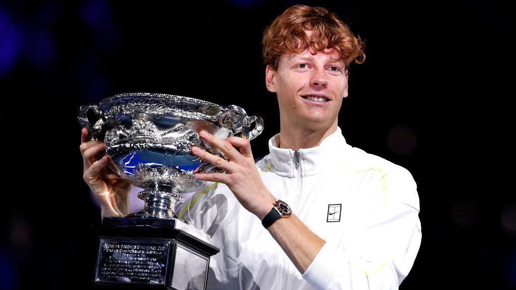 Jannik Sinner holds up the Australian Open men's singles trophy - the Norman Brookes Challenge Cup