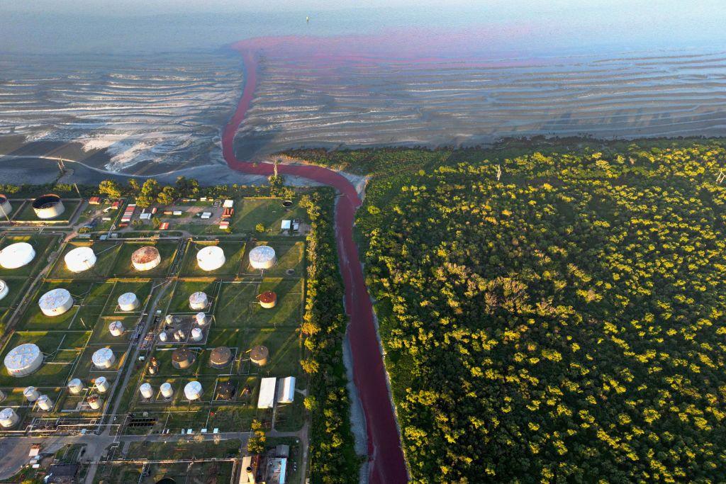 An aerial view shows an unusual reddish colour in the Sarandi Canal near the Rio de la Plata River in Sarandi, Avellaneda, on the outskirts of Buenos Aires. The red liquid is seen pouring into the sea in the distance.
