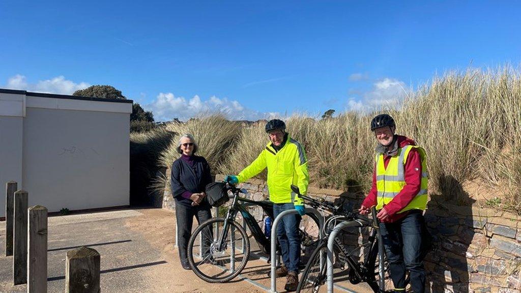 Close up of Councillors Marianne Rixson, Olly Davey and Geoff Jung next to the new bike parking spaces on Exmouth seafront