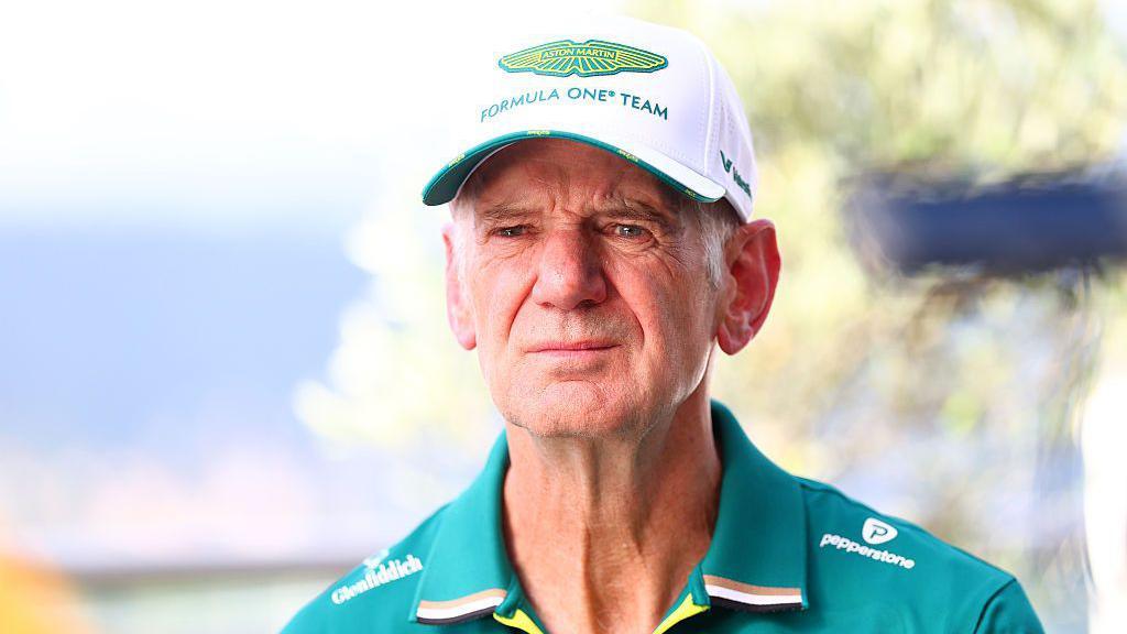 Adrian Newey wearing an Aston Martin cap and team kit
