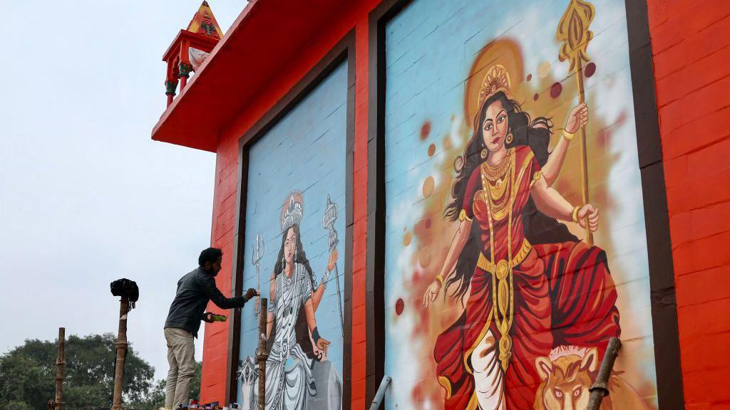 A man paints murals of Hindu deities on the Alopi Devi temple wall, ahead of the Maha Kumbh Mela festival in Prayagraj on December 31, 2024. (Photo by Niharika KULKARNI / AFP) (Photo by NIHARIKA KULKARNI/AFP via Getty Images)