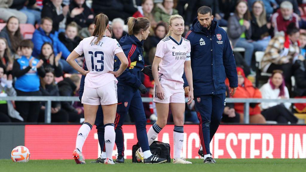 Leah Williamson being helped off the pitch after suffering an ACL injury.