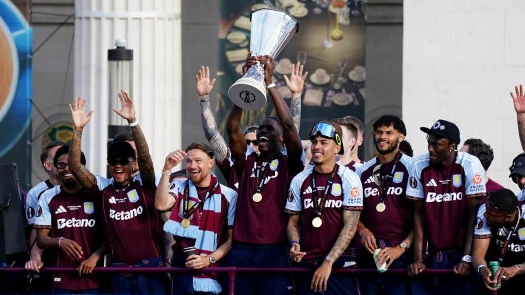 Aston Villa's Amadou Onana lifts the trophy during the Europa League winners parade in Birmingham
