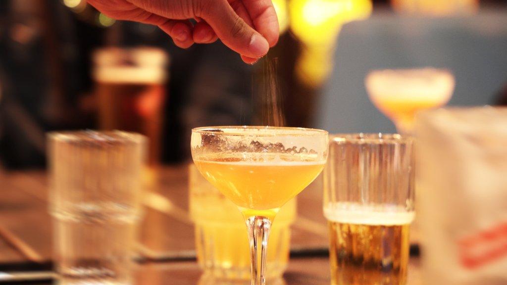 Drinks on a table with powder being placed in one