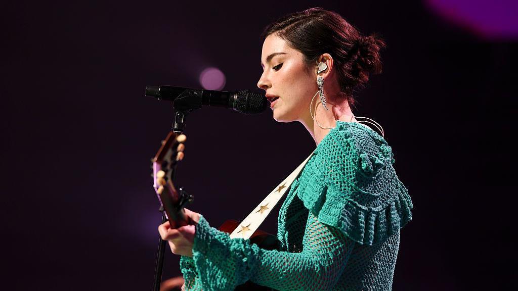 Gracie Abrams performing with a guitar.
