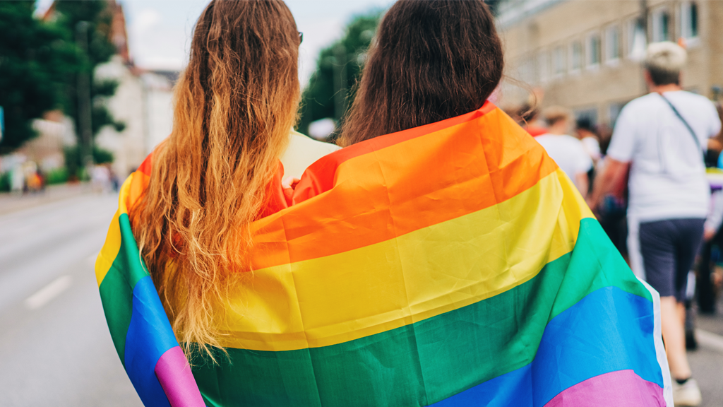 LGBTQ flag on two people's backs