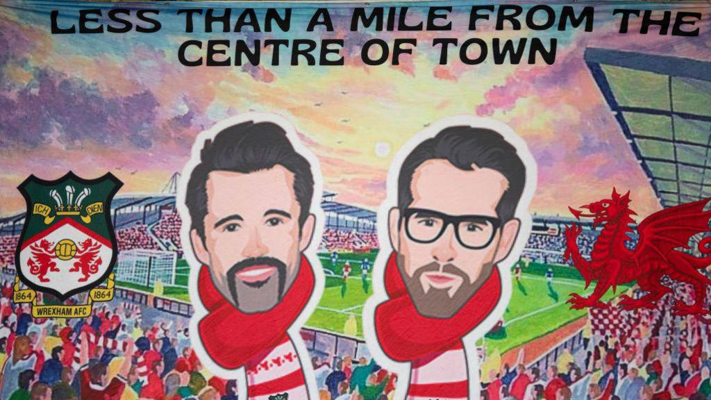 A mural showing Ryan Reynolds and Rob McElhenney in front of the Racecourse