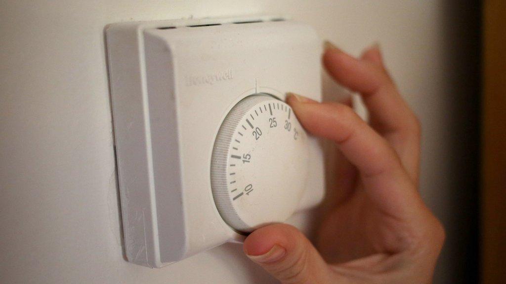 Hand adjusting a thermostat