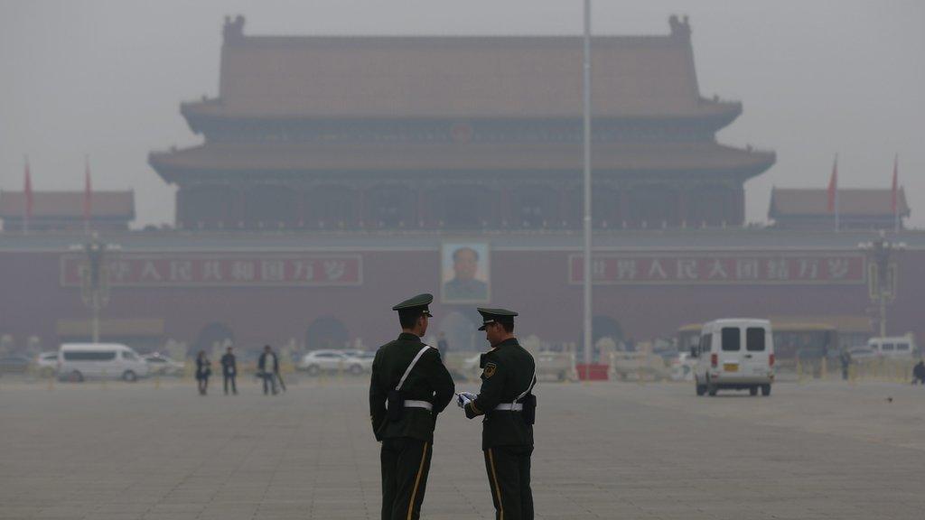 Two paramilitary policemen guard in Beijing's Tiananmen Square during a haze day