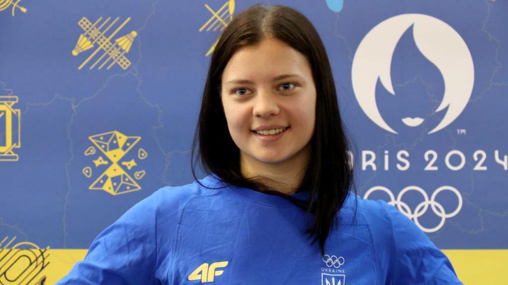 Ukrainian diver Sofiia Lyskun holds a national flag during the welcome ceremony at the Central Railway Terminal upon her return from the Paris 2024 Olympics