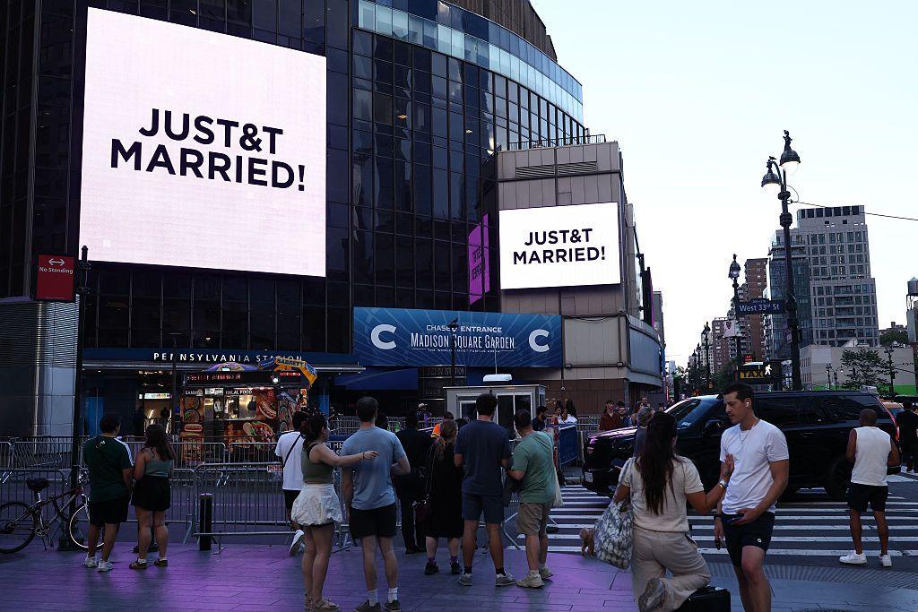 People watch giant screens showing the message 