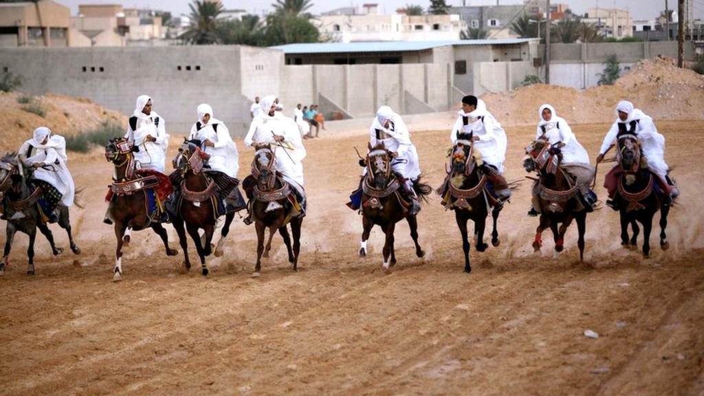 Libyans dressed up in traditional costumes ride horses during a race in Tripoli, Libya, August 19, 2017. Picture taken August 19, 2017.