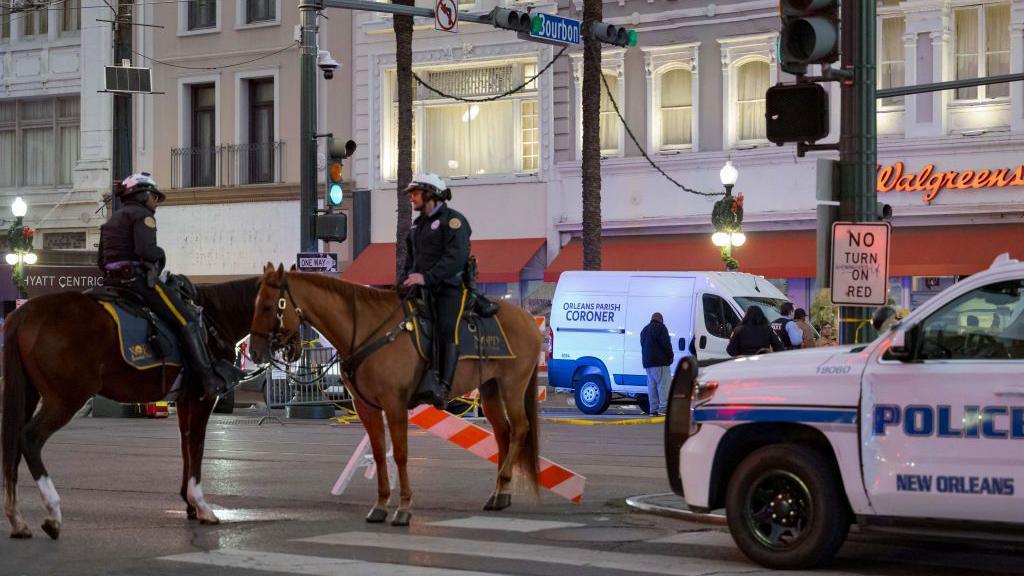 The scene at the intersection of Bourbon Street and Canal Street remains cordoned off by police