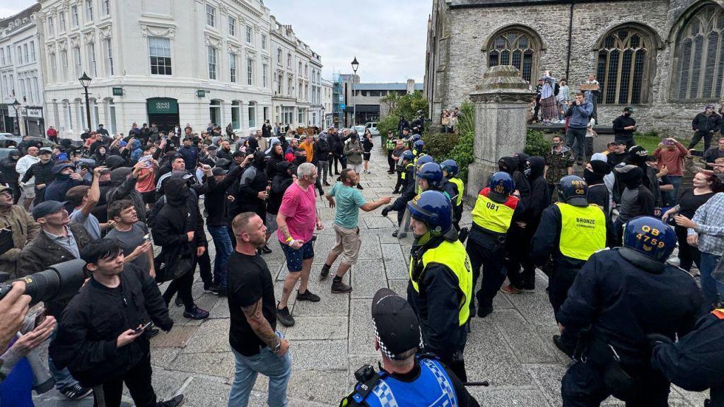 People clashing with police outside the Guildhall in Plymouth