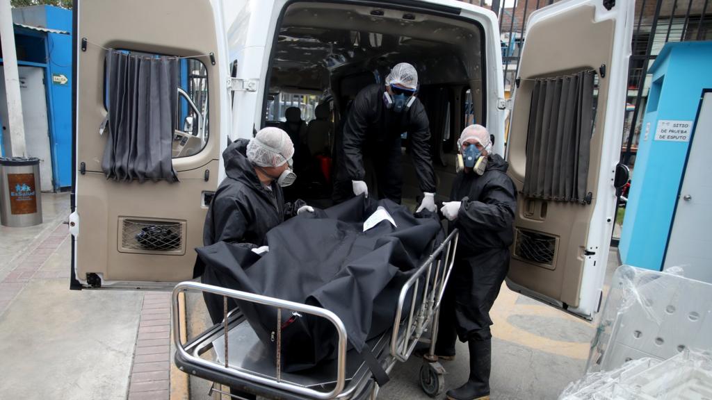 Funeral workers put the body of a victim of COVID 19 in the van on assignment for the national government of Peru at Aurelio Diaz Ufano Hospital on June 18, 2020 in Lima, Peru