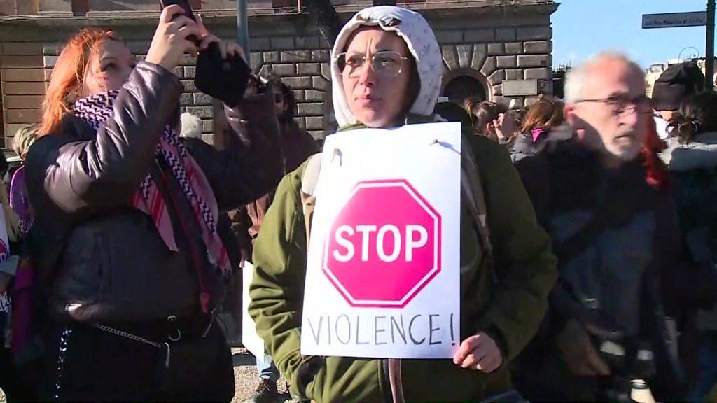 Protester holding up sign saying "stop violence" in Rome, Italy.