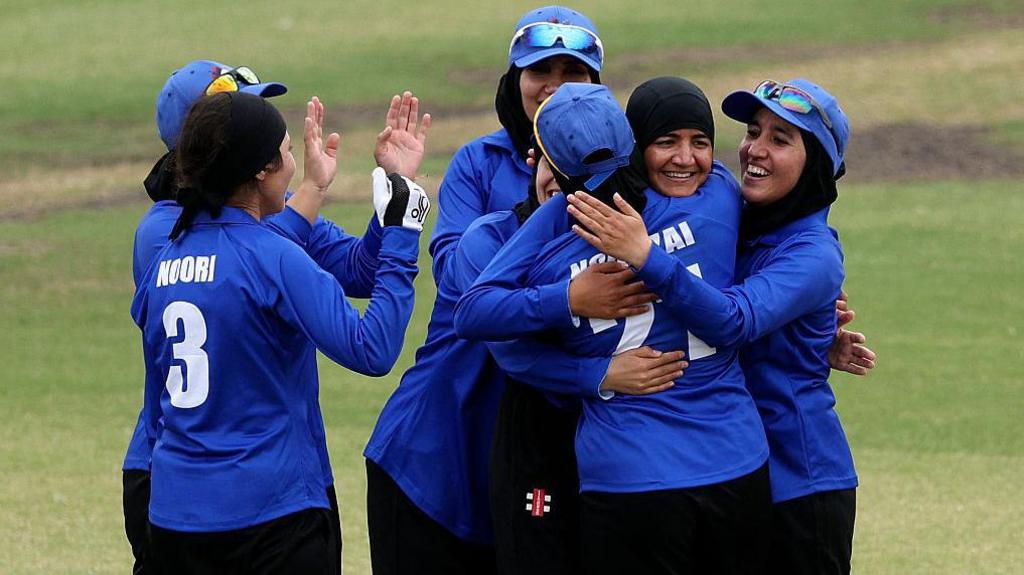 Afghanistan's women celebrate a wicket during a T20 match against Cricket Without Borders XI at Junction Oval in Melbourne in 2025