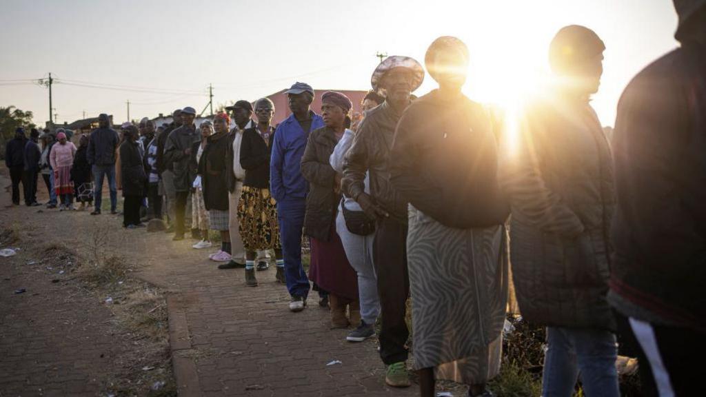 Residents queue to vote as they wait for the Rekgutlile Primary School polling station to open in Orange Farm, south of Johannesburg on May 29, 2024, during South Africa's general election. 