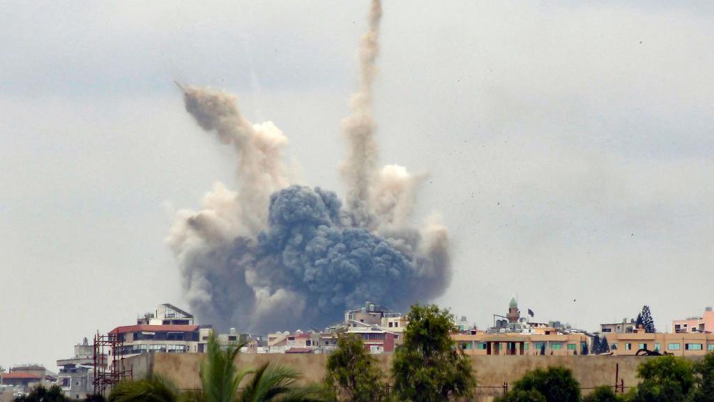 A photo taken from the southern Lebanese city of Tyre shows smoke billowing from a nearby village following an Israeli strike (7 October 2024)