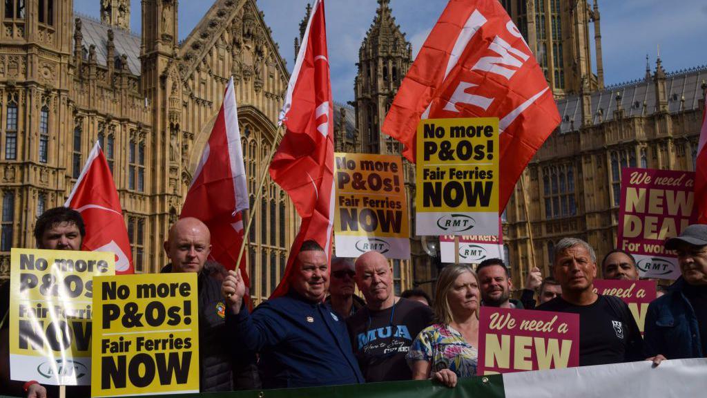 Protestors outside Parliament holding placards criticising the employment practices of P&O ferries.