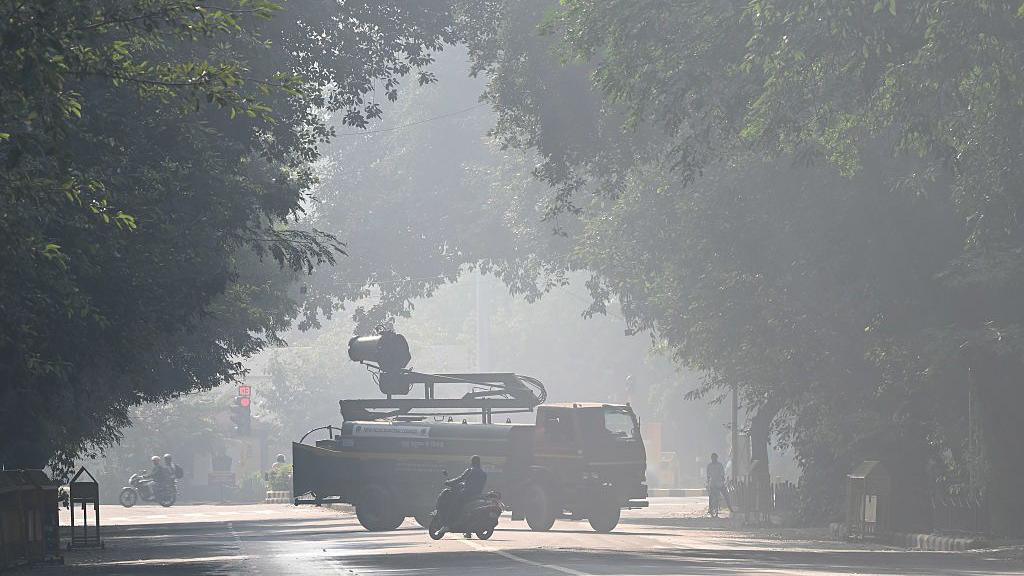 A truck with a smog gun spraying water to control air pollution on the streets of Delhi.