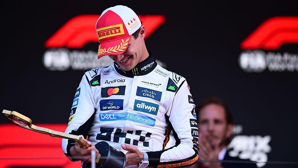 Lando Norris smiling at his trophy